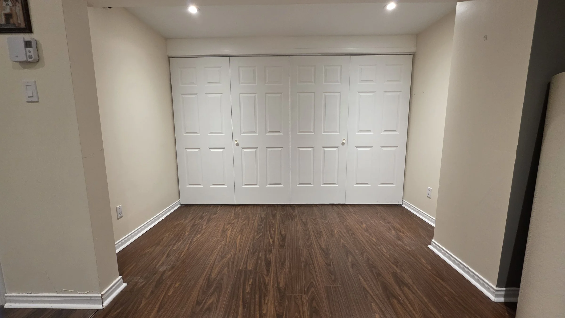 White six-panel bifold closet doors in a finished basement in Gatineau, QC
